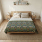 Bedroom with a floral quilt on a bed, wooden nightstands, and framed pictures on the wall.