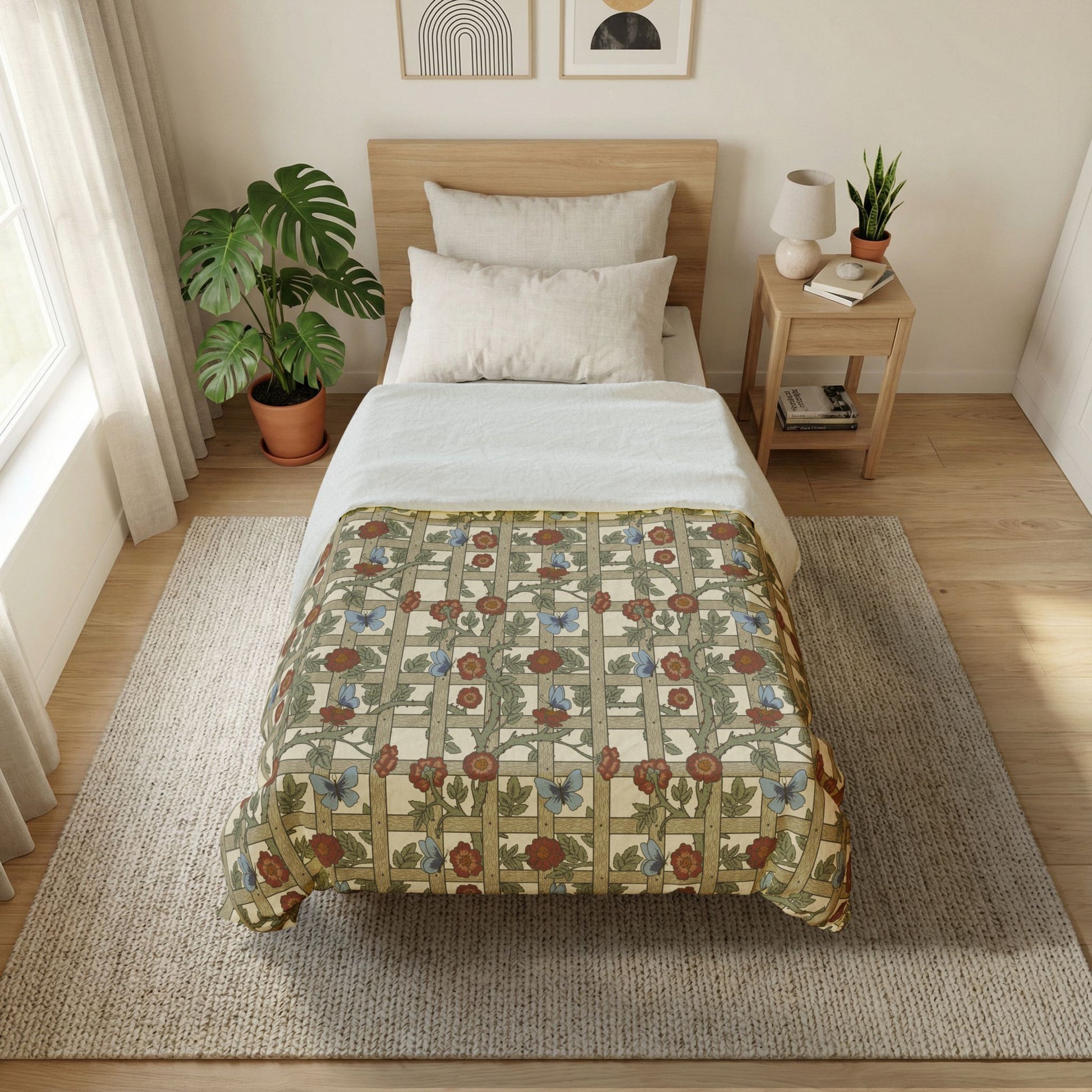Bedroom with floral-patterned comforter on a bed, side table with lamp and books, and plants.