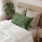 Decorative pillow with a fist and hammer design on a bed in a bedroom setting.