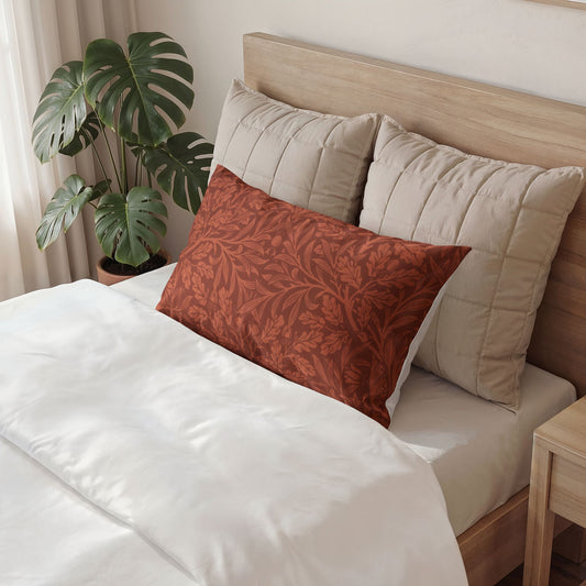 Bed with beige pillows and a red patterned pillow, next to a plant and wooden nightstand.