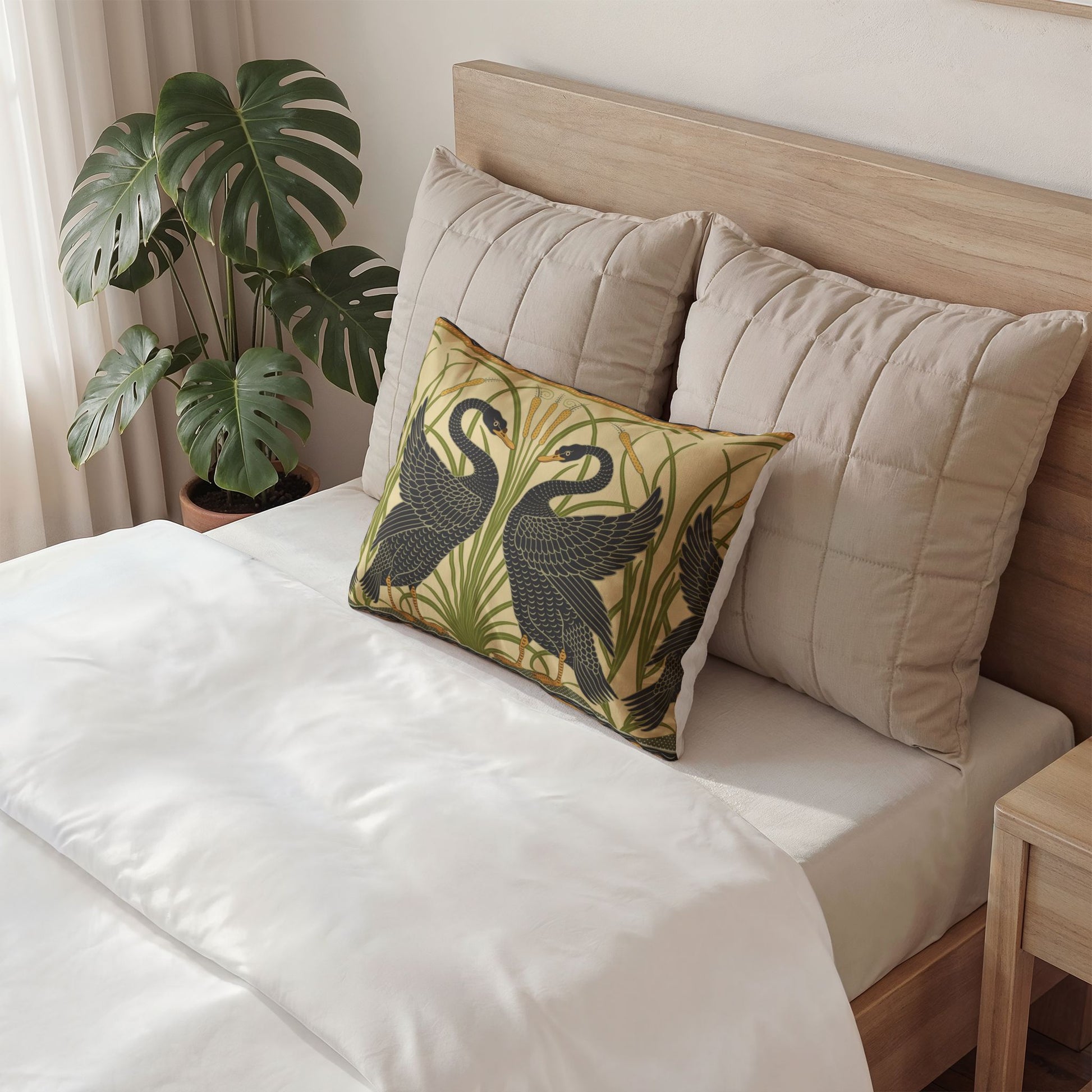Decorative pillow with swan design on a bed in a bedroom setting
