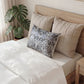 Decorative pillow with floral pattern on a bed in a bedroom setting