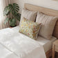 Decorative pillow with floral pattern on a bed in a bedroom setting