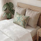 Decorative pillow with floral pattern on a bed in a bedroom setting
