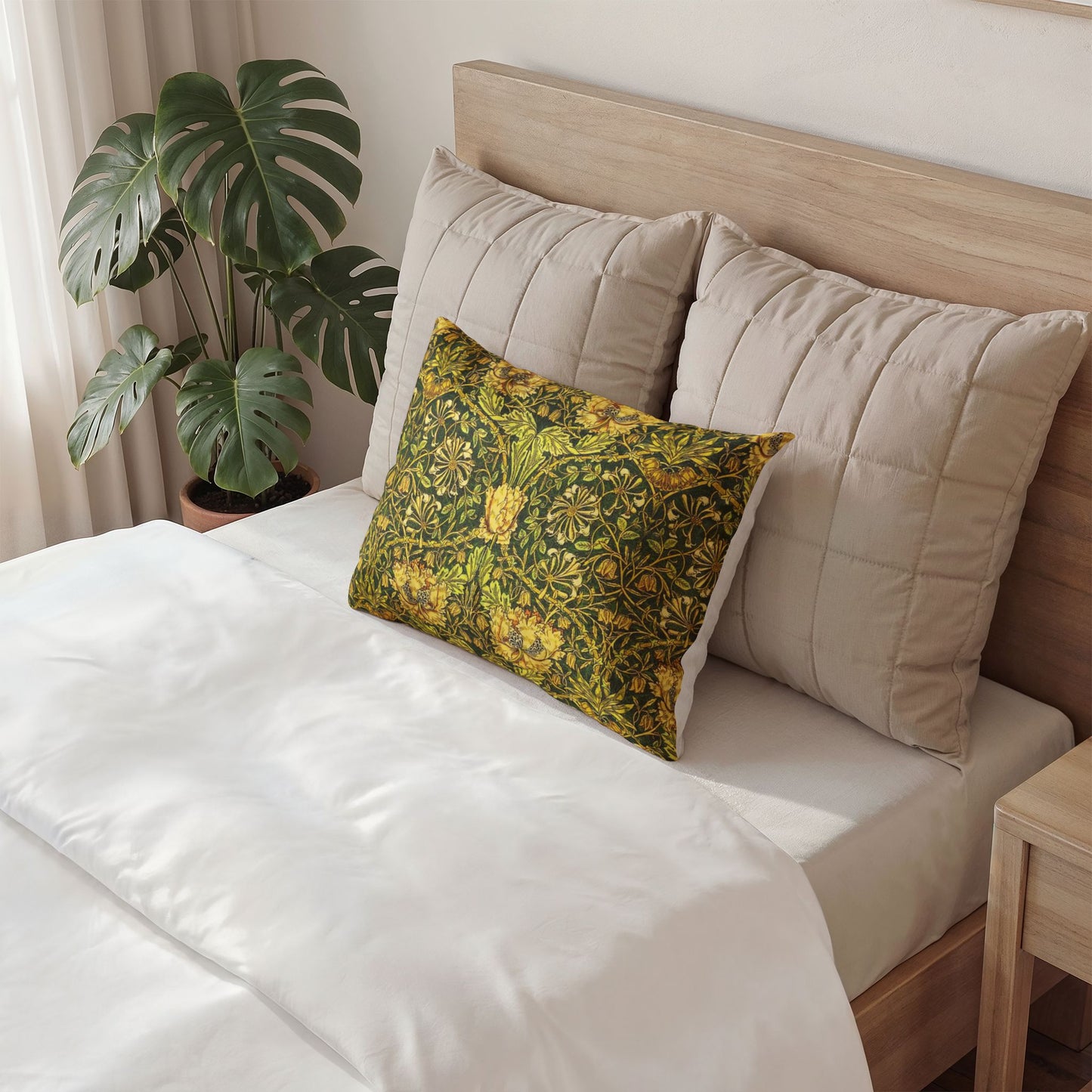 Bed with beige pillows and a decorative green pillow, next to a plant.