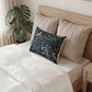 Bed with beige pillows and a black pillow with white patterns, next to a plant.