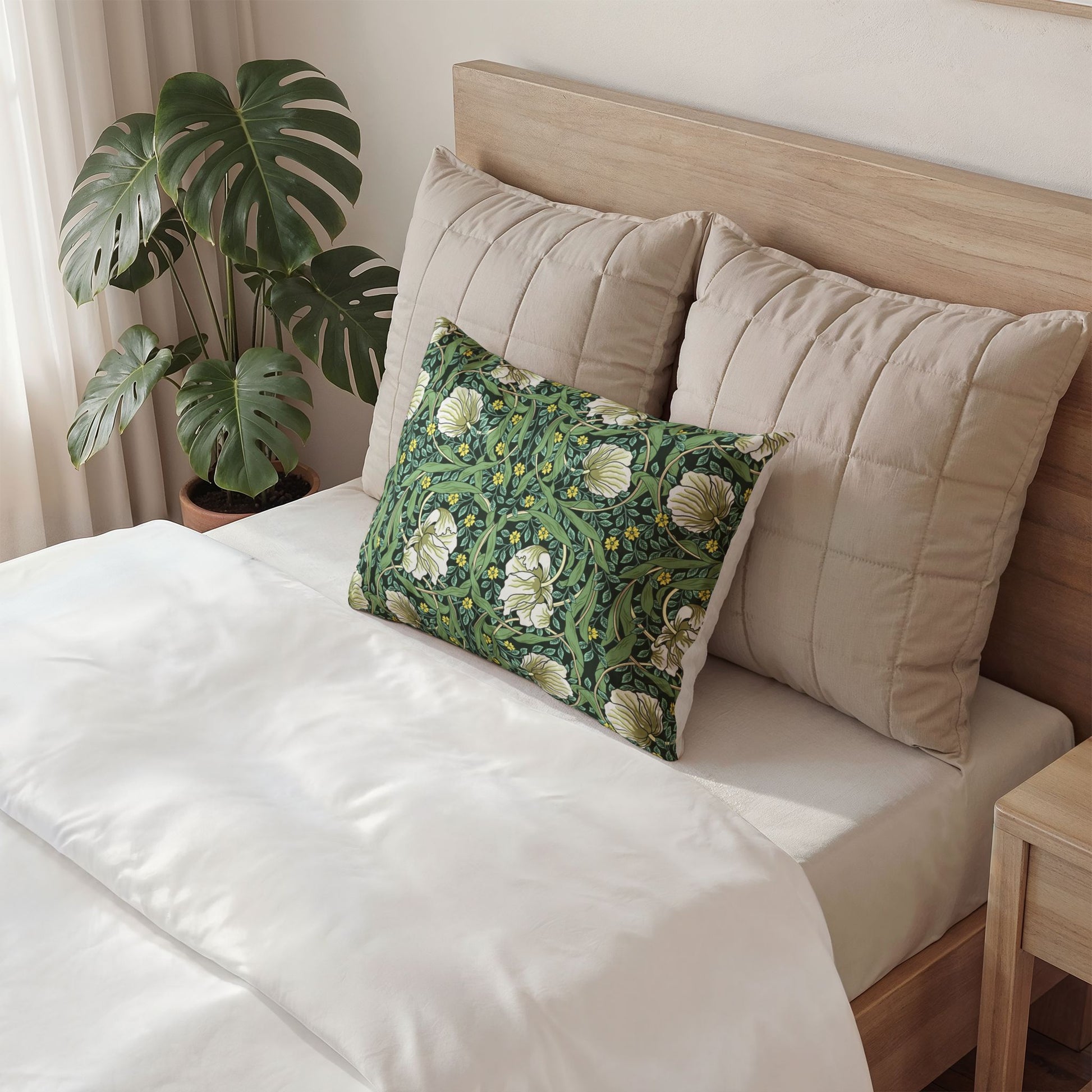 Neatly made bed with decorative pillows and a plant in the background