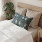 Neatly made bed with decorative pillows and a plant in the background