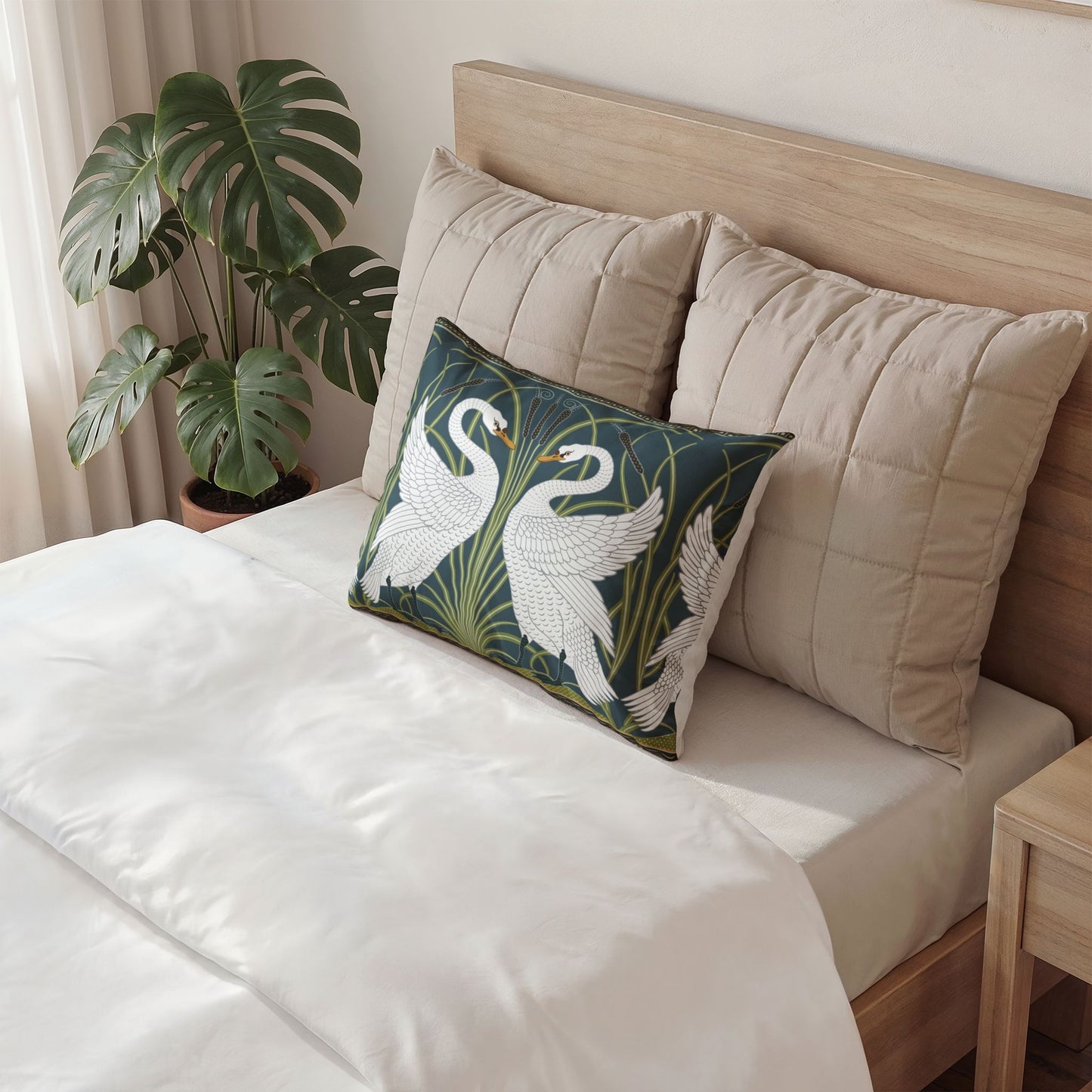 Decorative pillow with swan design on a bed in a bedroom setting