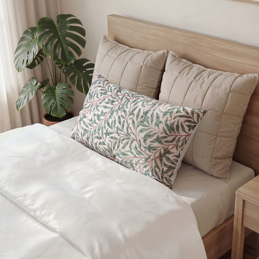 Neatly made bed with decorative pillows and a plant in the background