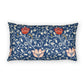 A rectangular lumbar throw pillow featuring a navy blue background with a dense floral and vine pattern in cream, coral-red, and muted gold, shown against a plain white background.