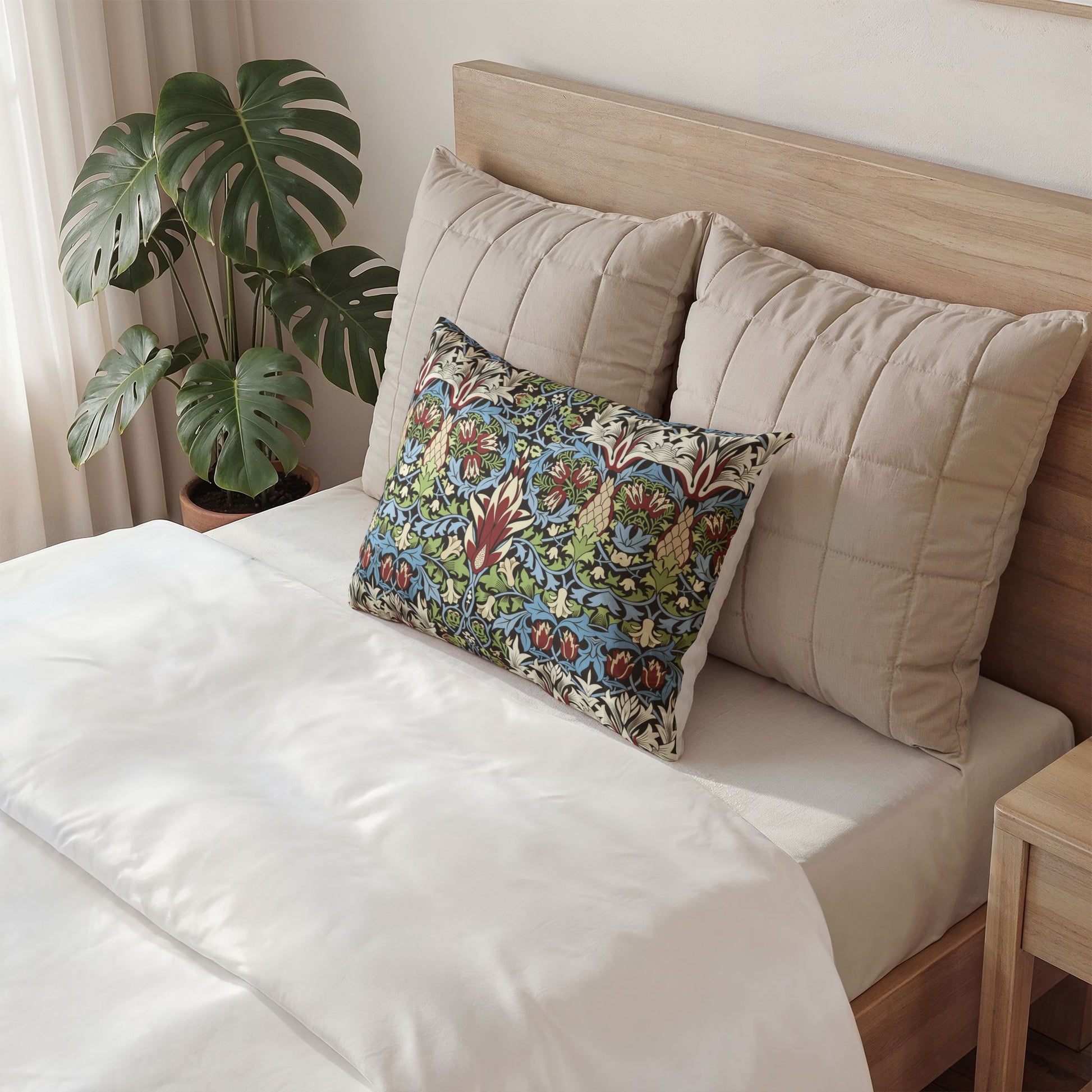 Decorative pillow on a bed with a plant in the background