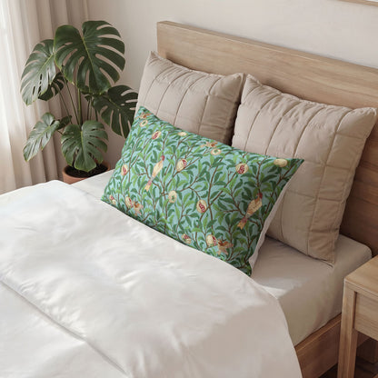 Bed with beige pillows and a green floral pillow, plant in the background