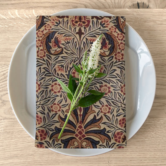 A floral patterned cotton twill napkin inspired by William Morris, displayed on a plate with a white flower garnish on top.