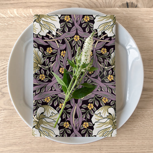 A floral patterned cotton twill napkin inspired by William Morris, displayed on a plate with a white flower decoration.