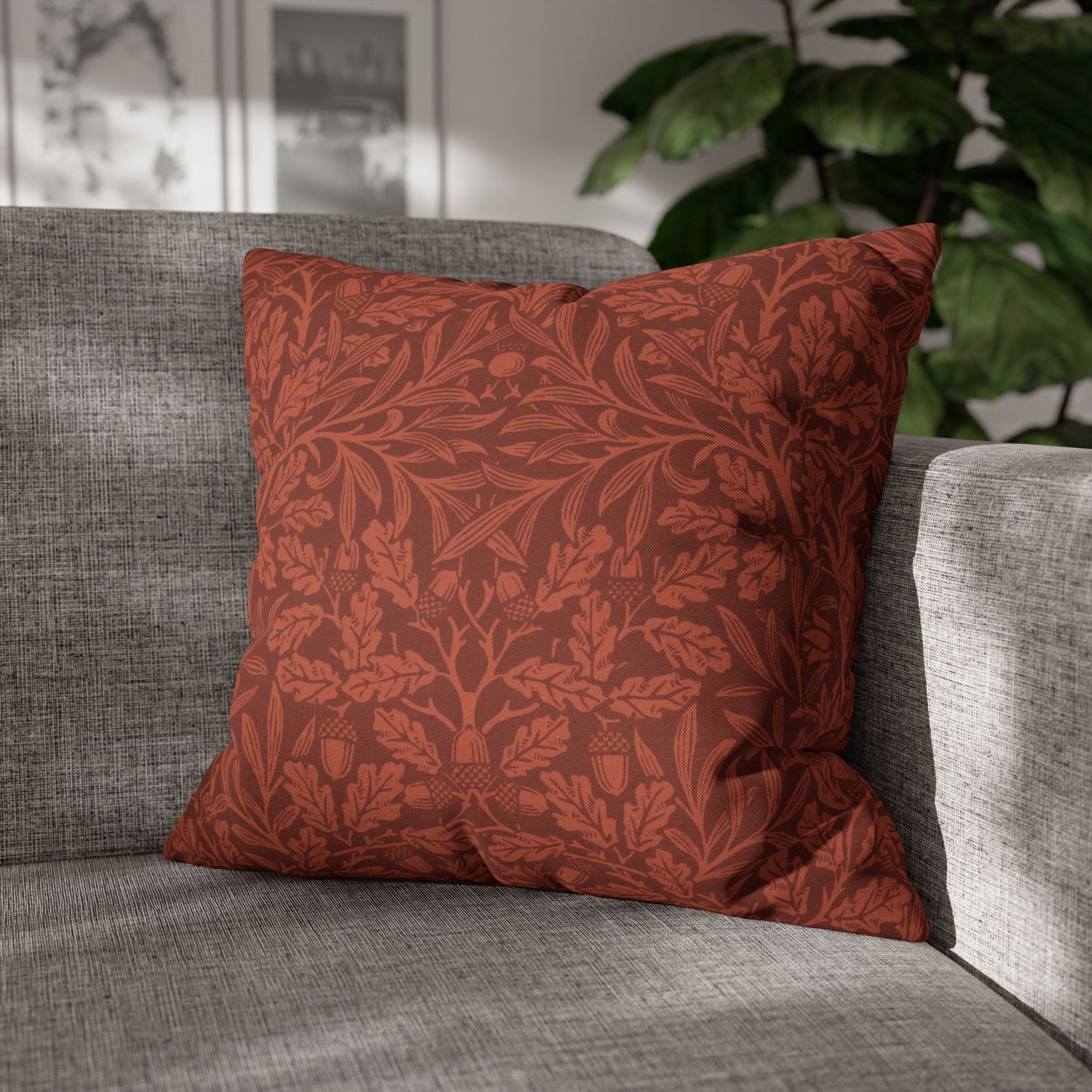 Red patterned pillow on a gray sofa with a blurred indoor background