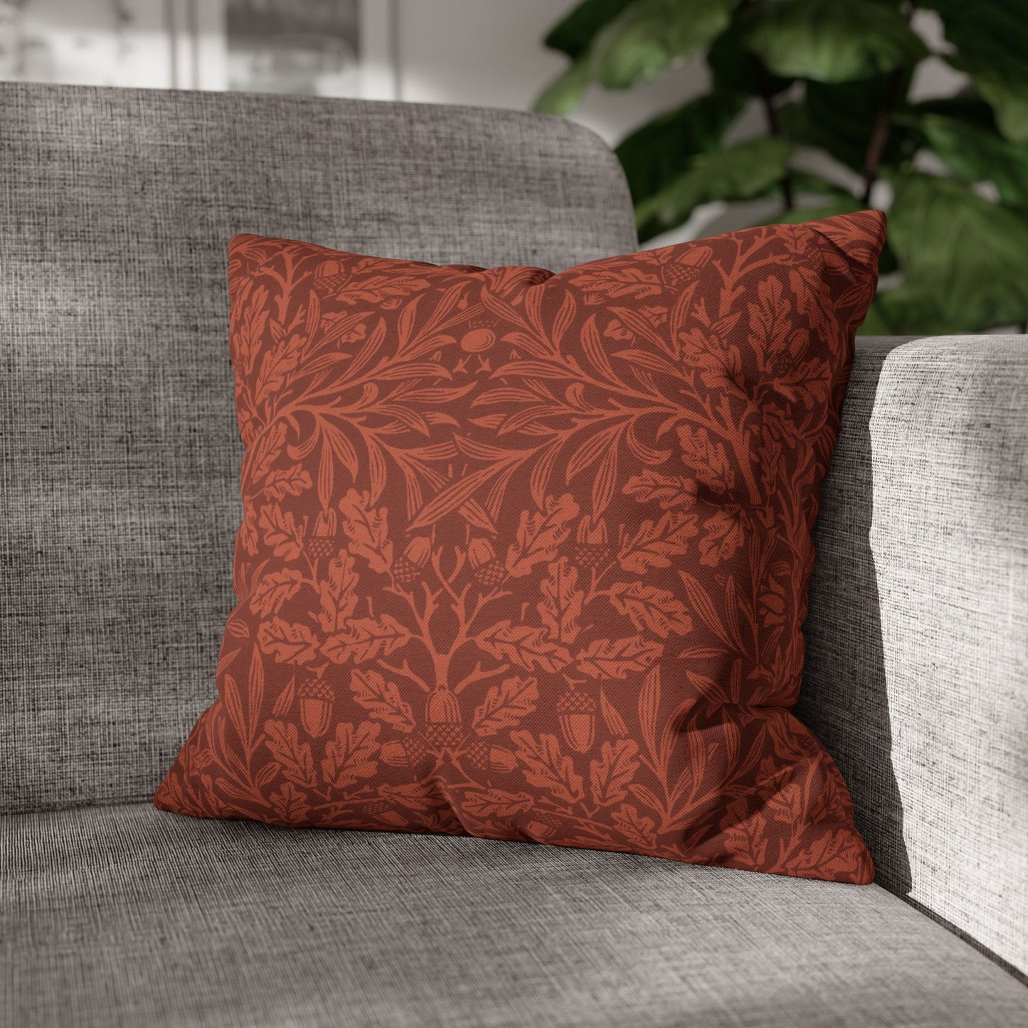 Red patterned pillow on a gray sofa with a blurred indoor background