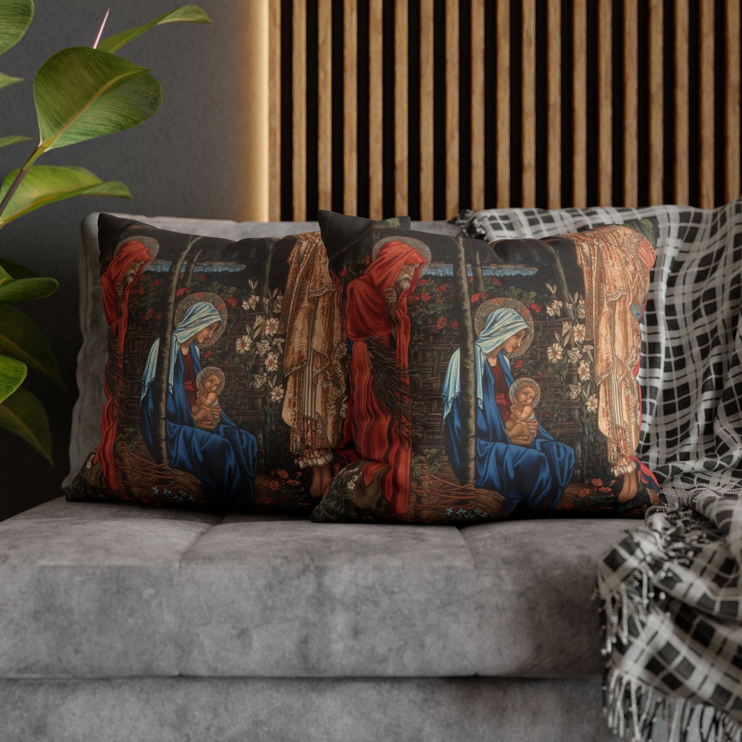 Decorative pillows with religious-themed design on a gray sofa.