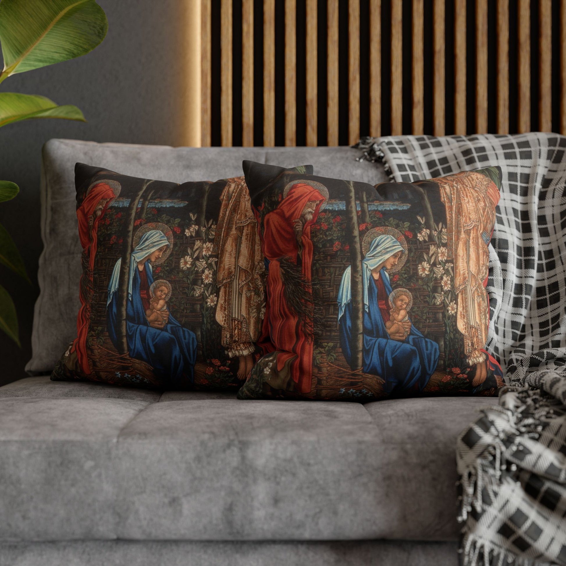 Decorative pillows with religious-themed designs on a gray sofa.