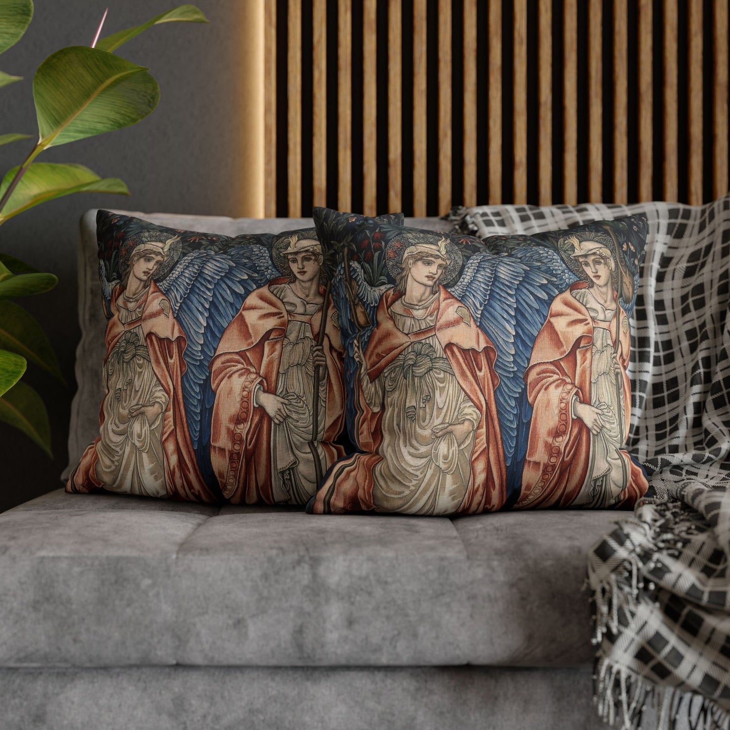 Decorative pillows with angel designs on a gray sofa.