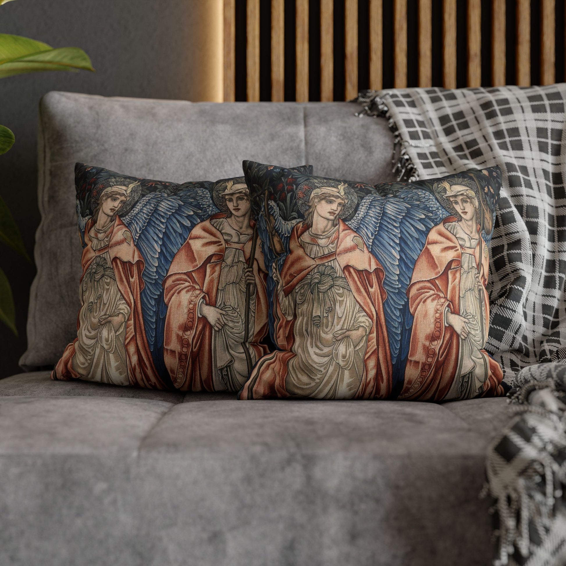 Decorative pillows with angel designs on a gray sofa.