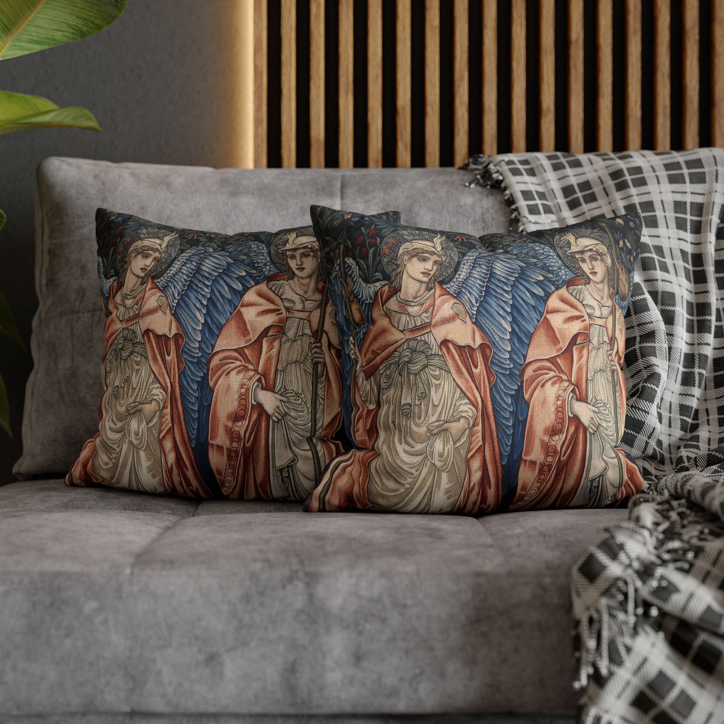 Decorative pillows with angel designs on a gray sofa.