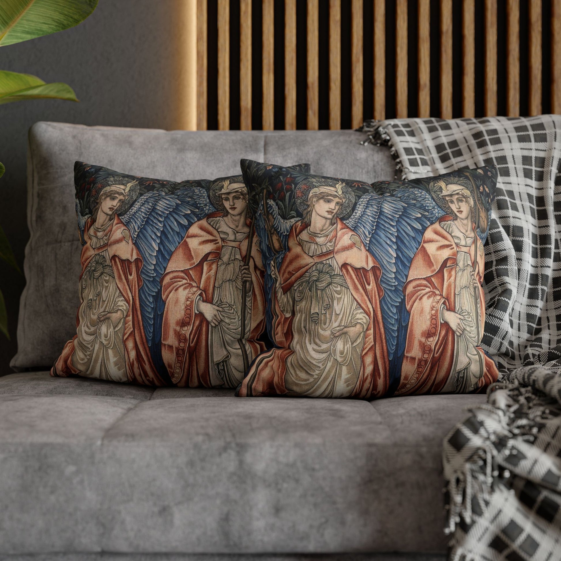 Decorative pillows with angel designs on a gray sofa.