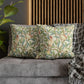 Decorative pillows with bird and floral pattern on a gray sofa.
