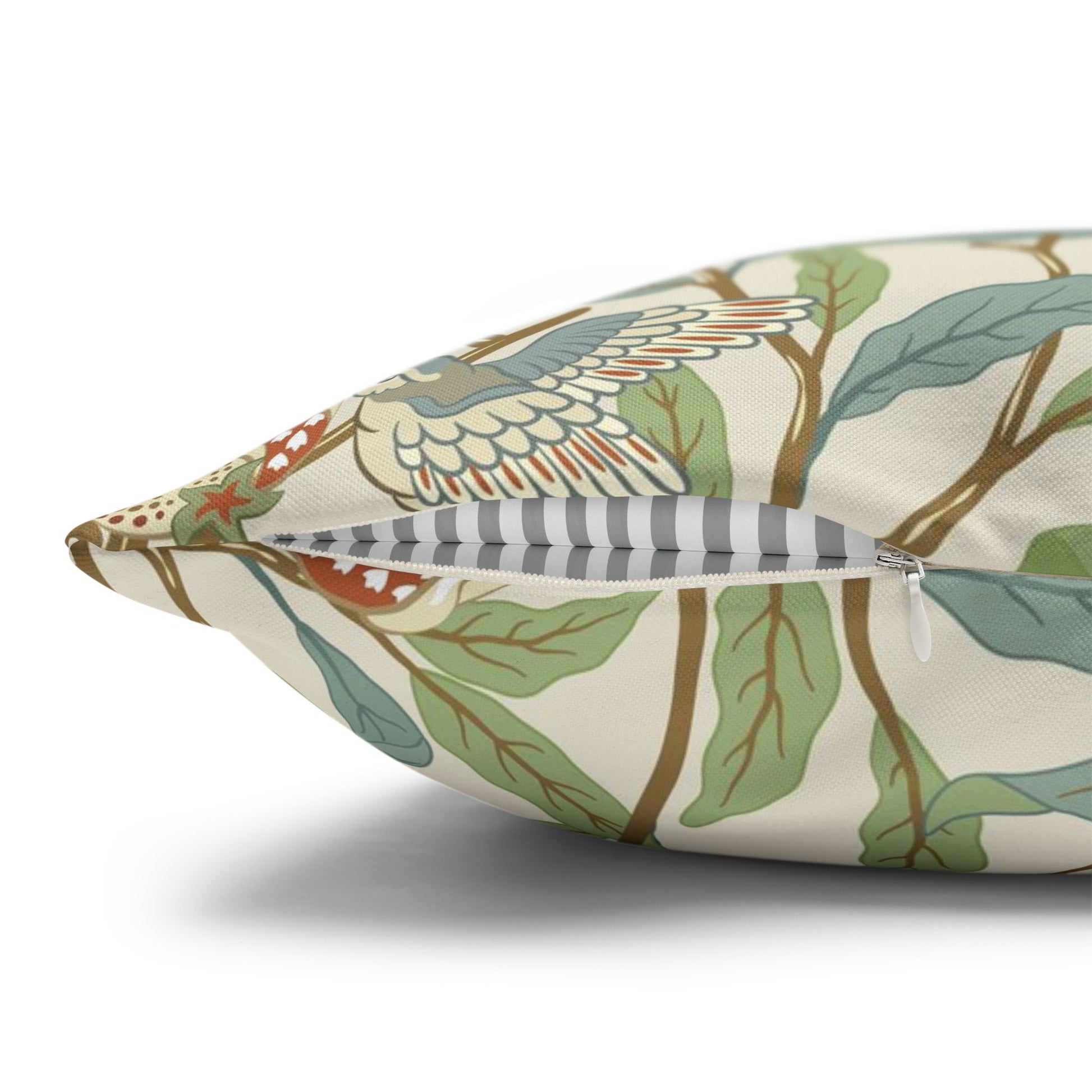 Decorative pillow with bird and leaf pattern on a white background