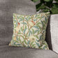 Decorative pillow with bird and floral pattern on a gray sofa
