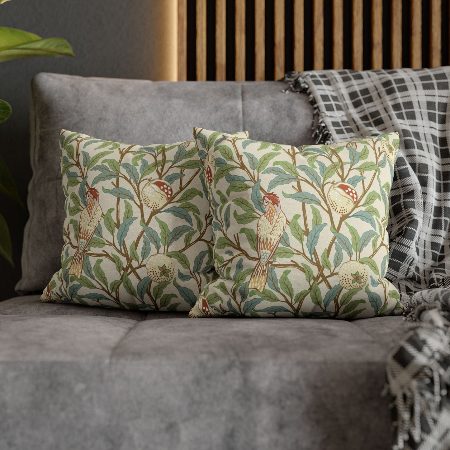 Decorative pillows with bird and floral pattern on a gray sofa.
