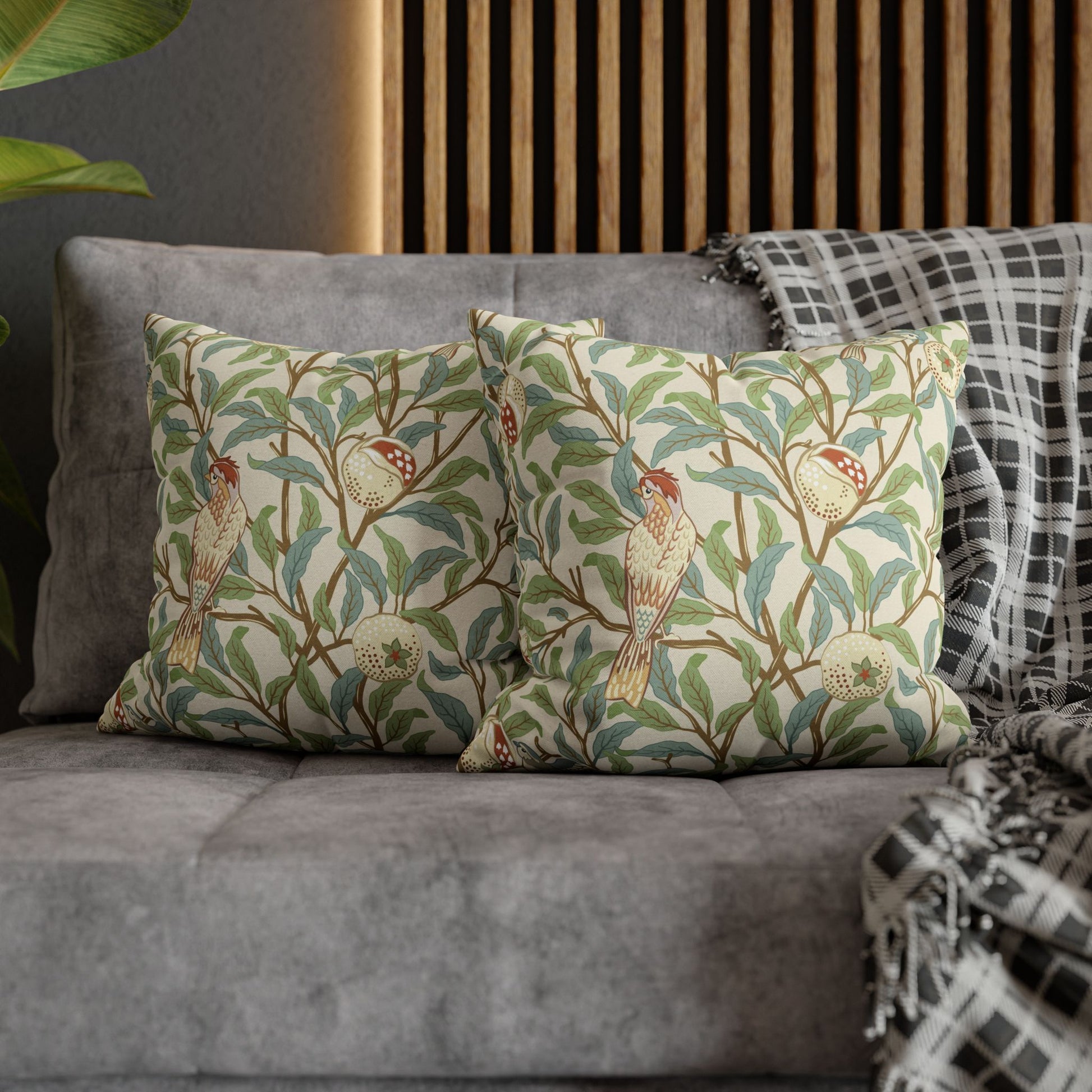 Decorative pillows with bird and floral pattern on a gray sofa.