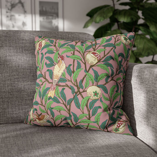 Decorative pillow with bird and leaf pattern on a gray sofa