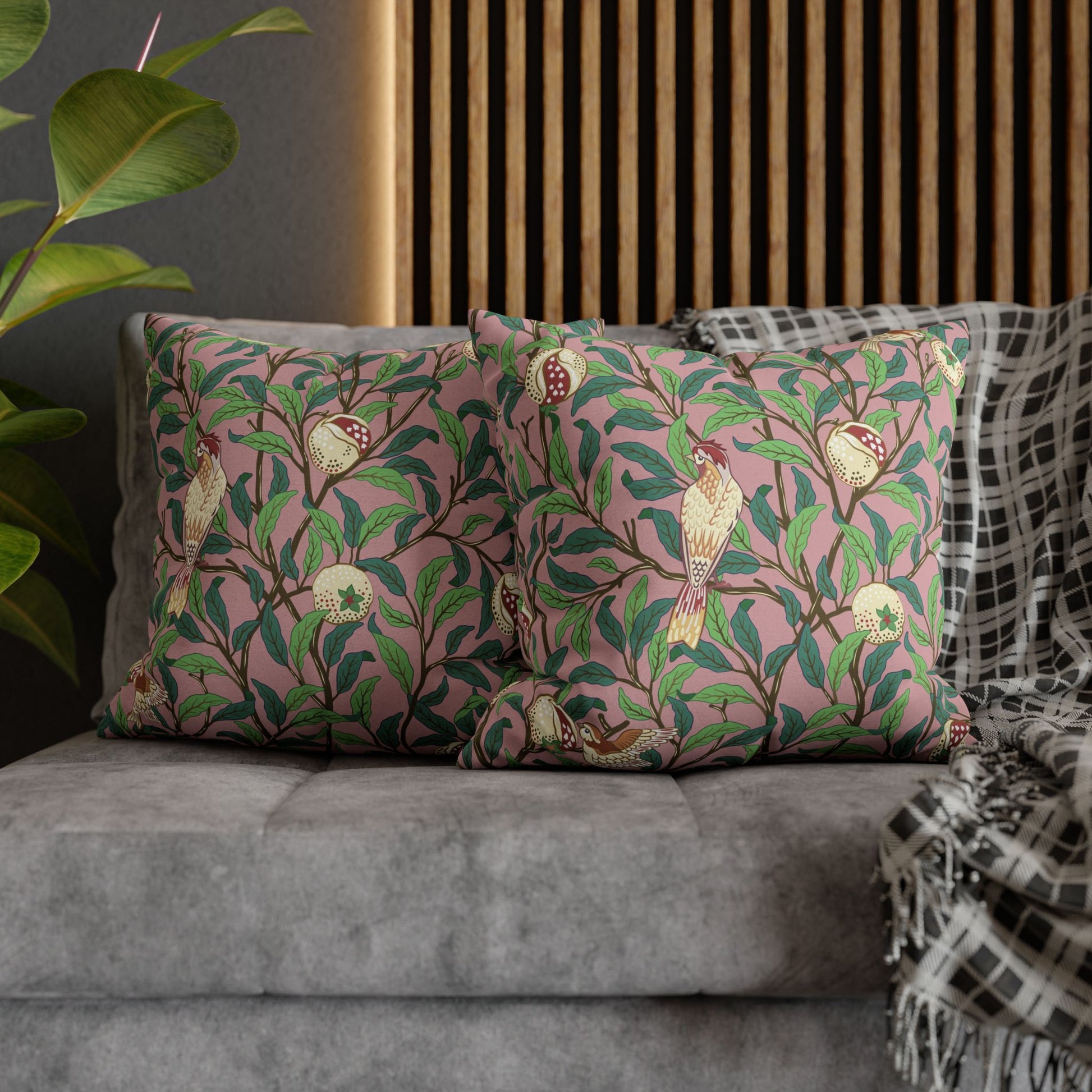 Decorative pillows with floral and bird pattern on a gray sofa.