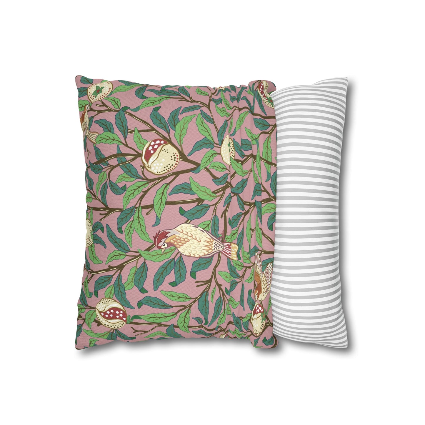 Decorative pillow with bird and leaf pattern next to a plain striped pillow on a white background