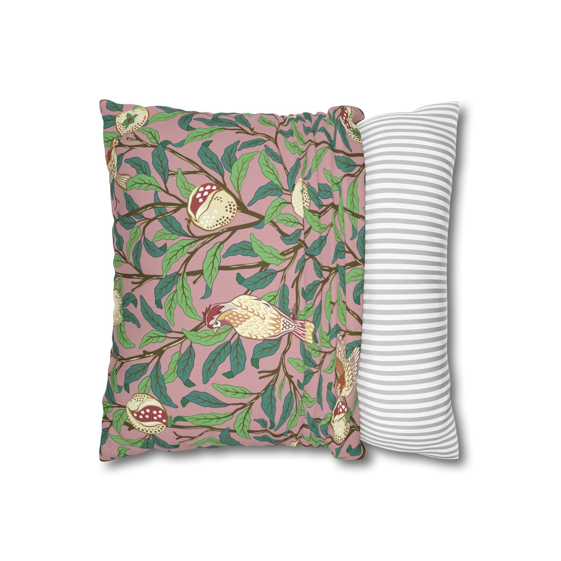 Decorative pillow with bird and leaf pattern next to a plain striped pillow on a white background