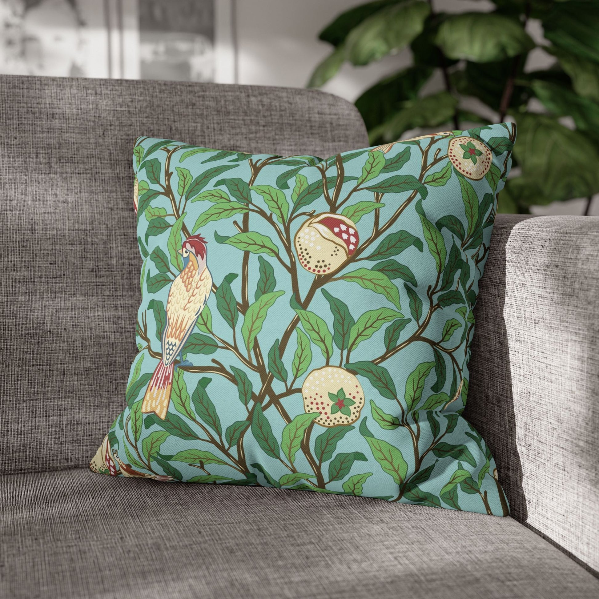 Decorative pillow with bird and fruit pattern on a gray sofa