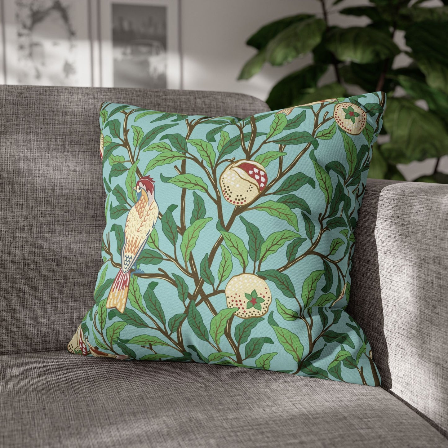 Decorative pillow with bird and fruit pattern on a gray sofa