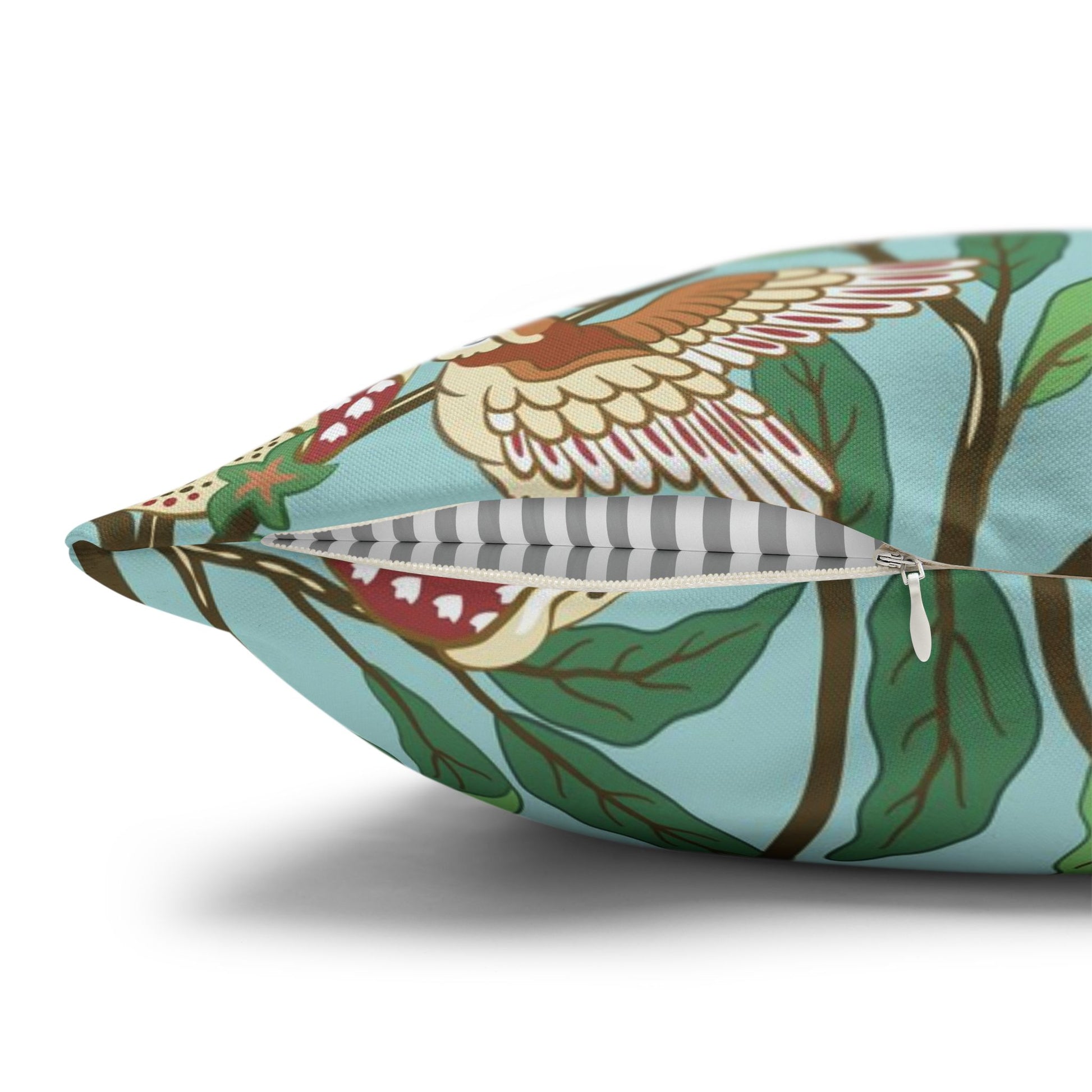 Decorative pillow with bird and leaf pattern on a white background