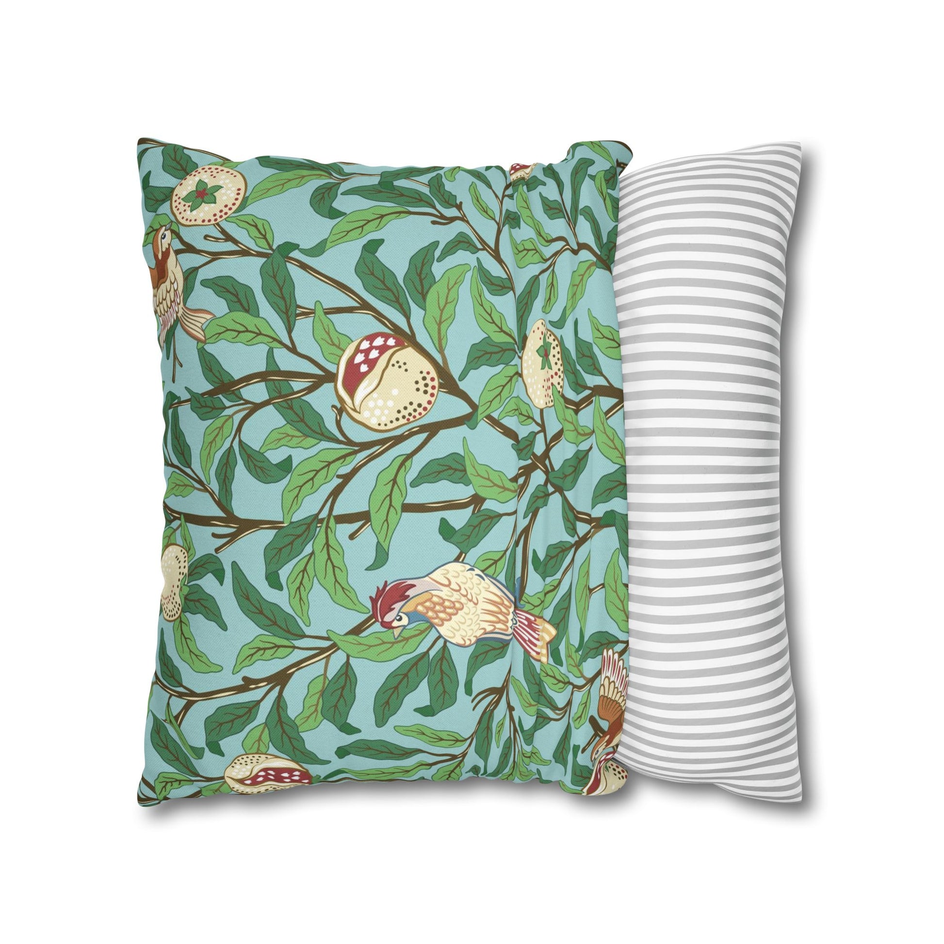 Decorative pillow with bird and branch pattern next to a striped pillow on a white background