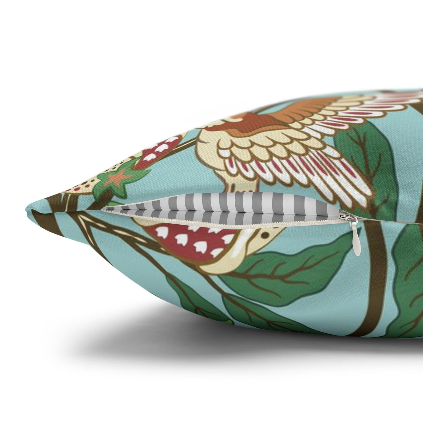Decorative pillow with bird and leaf pattern on a white background