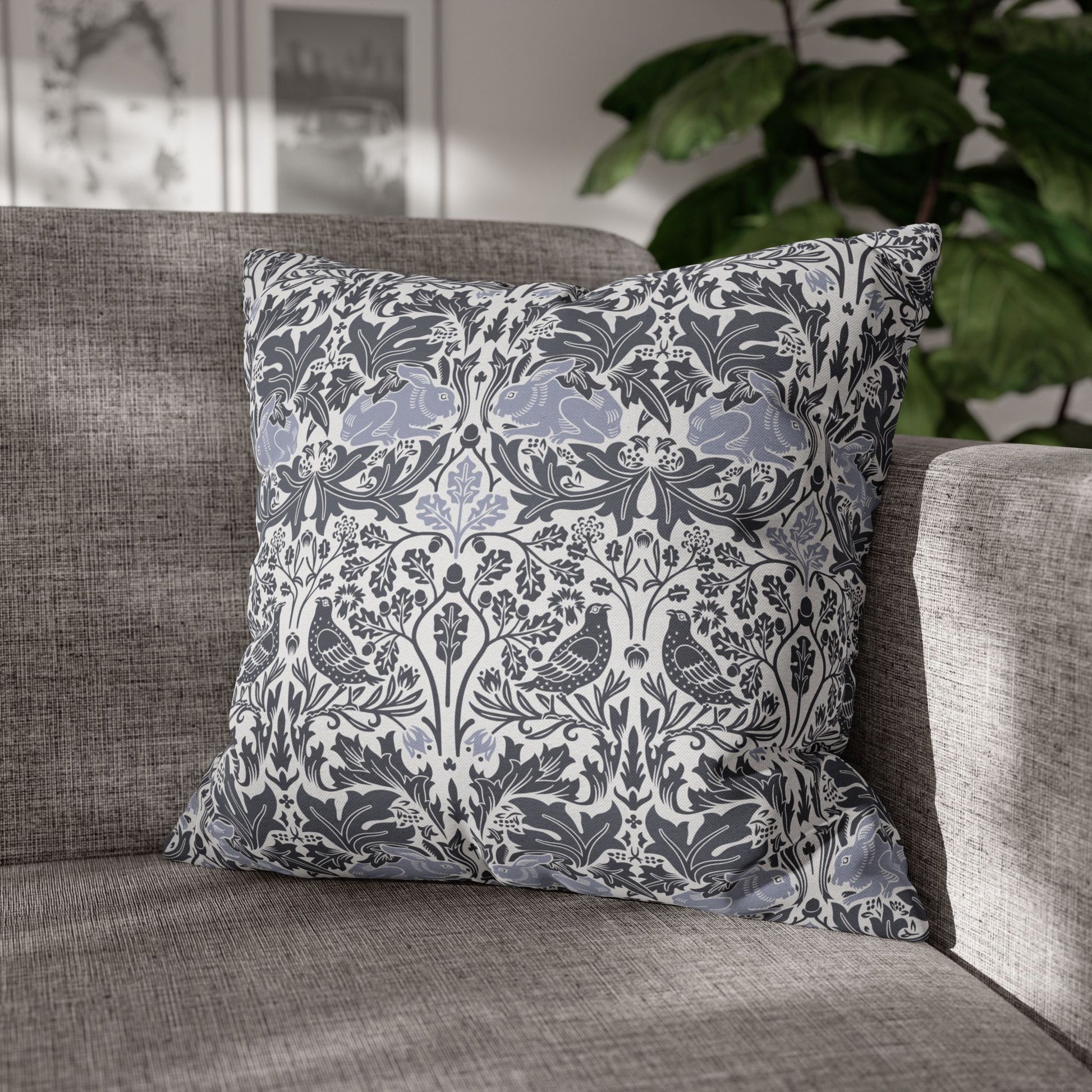 Decorative pillow with floral and bird pattern on a gray sofa
