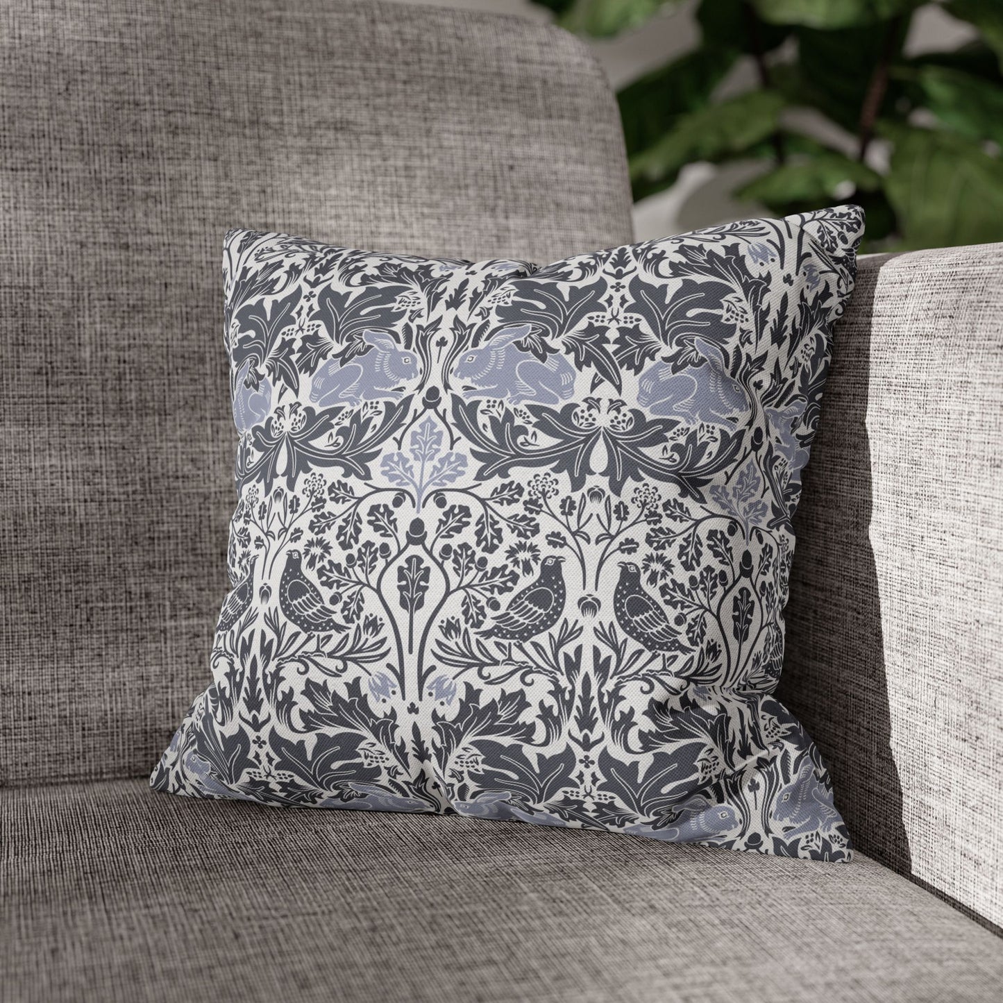 Decorative pillow with floral and bird pattern on a gray sofa