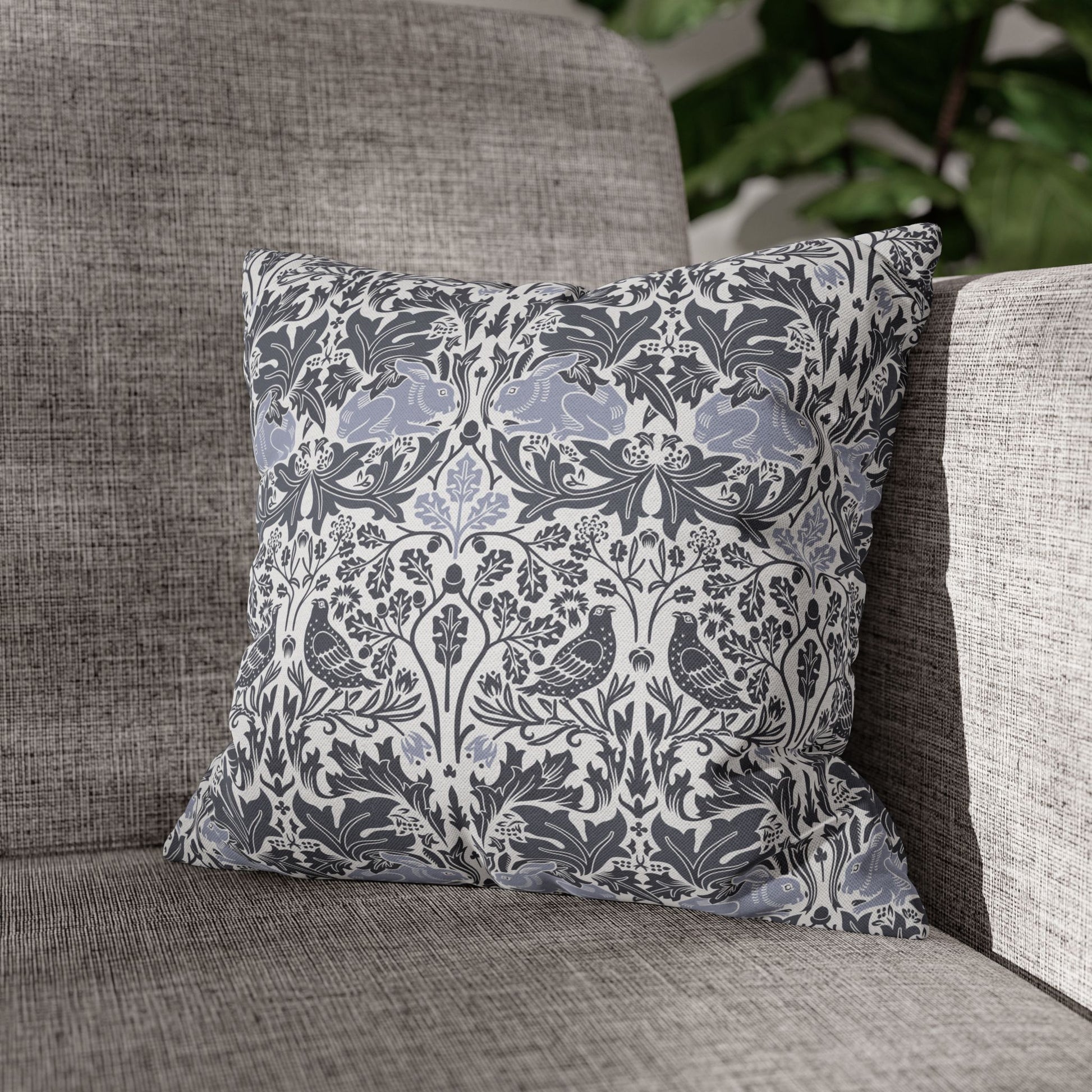 Decorative pillow with floral and bird pattern on a gray sofa