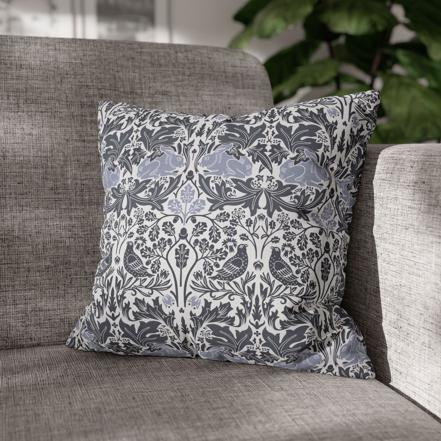 Decorative pillow with floral and bird pattern on a gray sofa