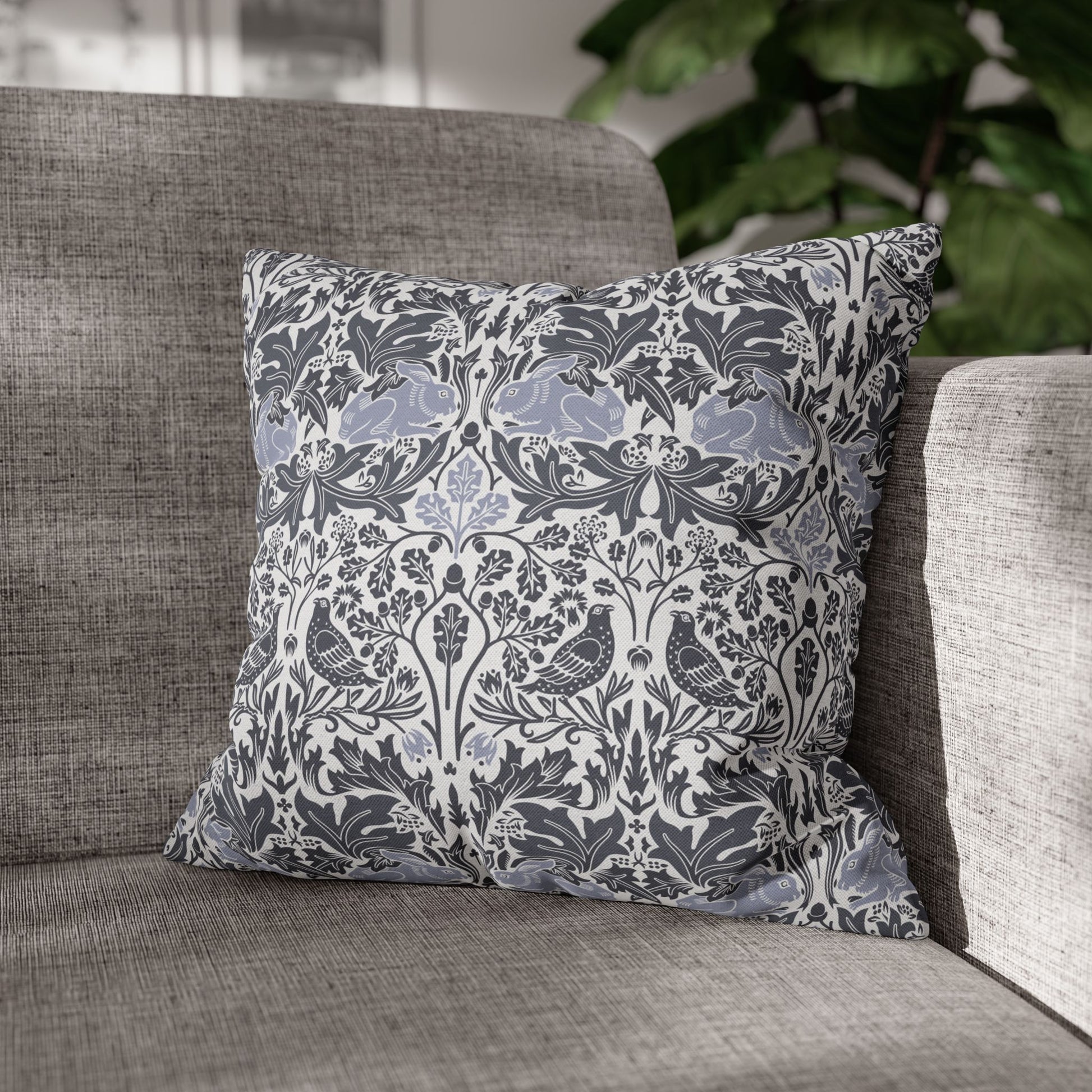 Decorative pillow with floral and bird pattern on a gray sofa