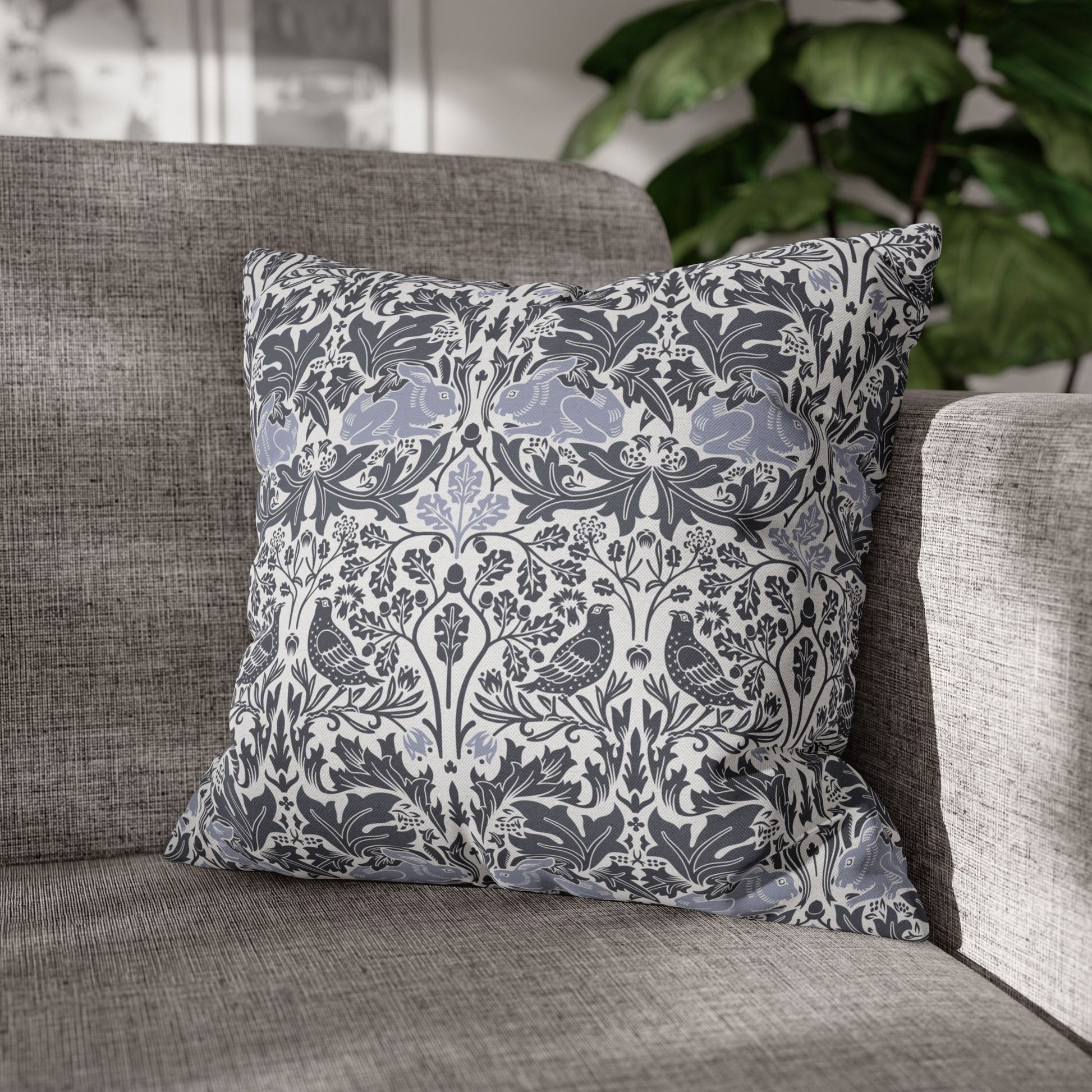Decorative pillow with floral and bird pattern on a gray sofa
