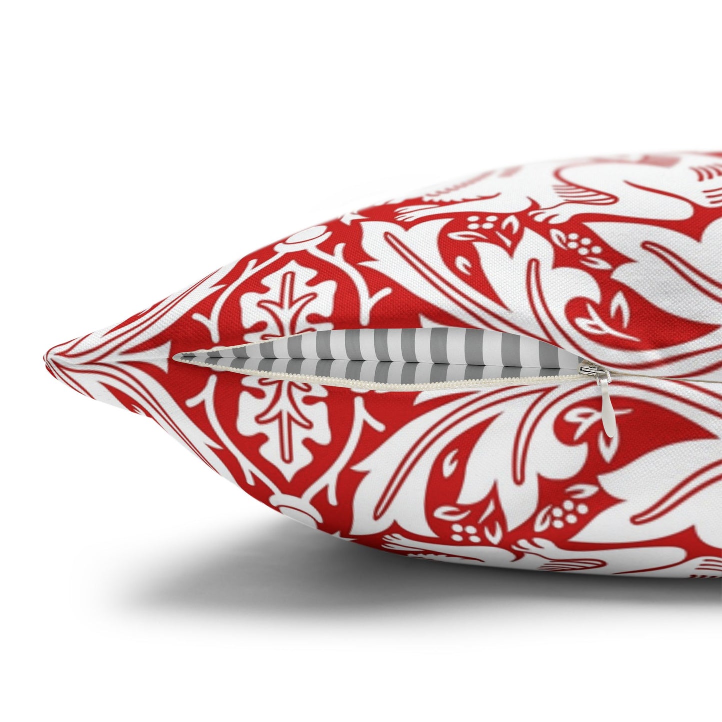 Red and white patterned pillow with a zipper on a white background