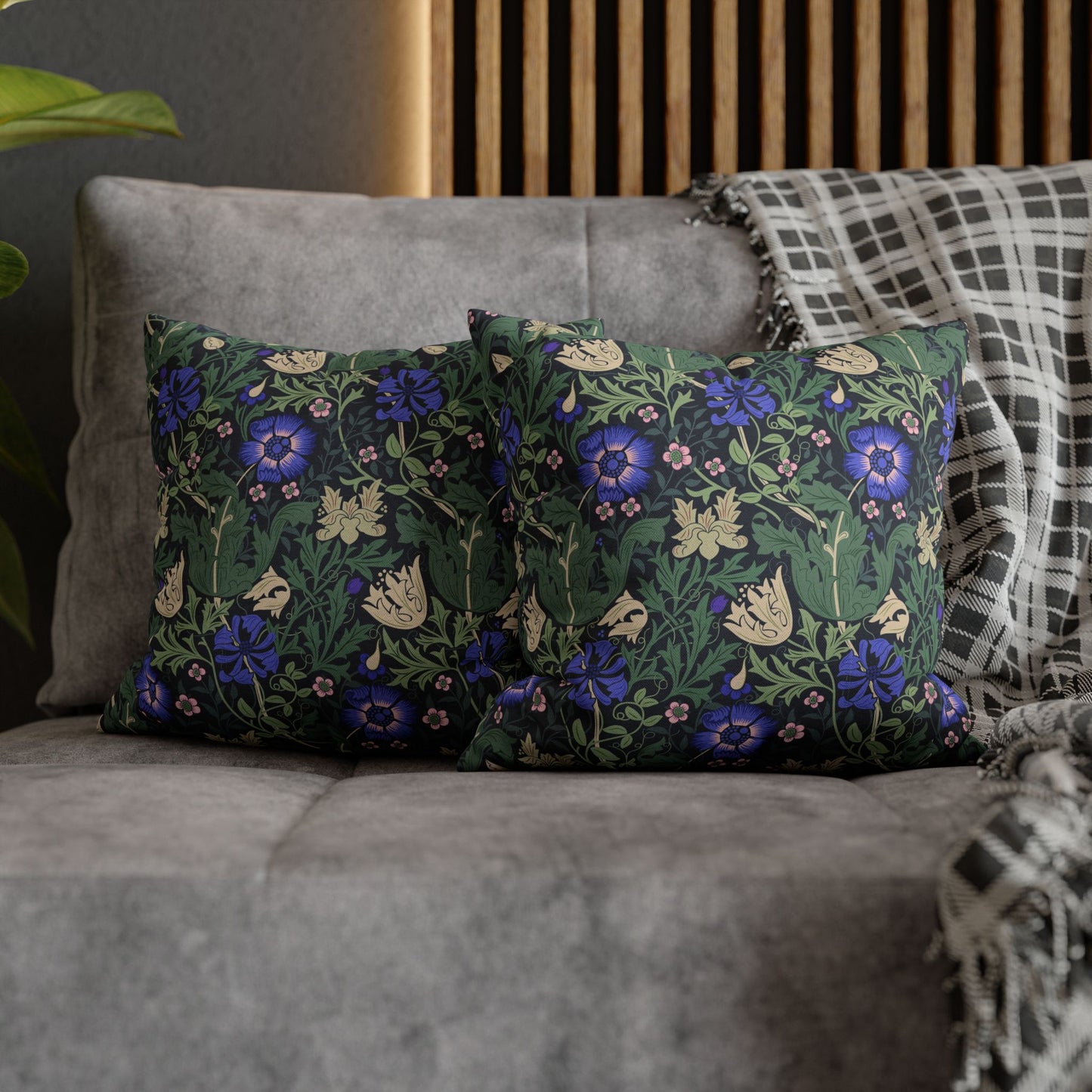 Floral patterned cushions on a gray sofa with a wooden headboard in the background.