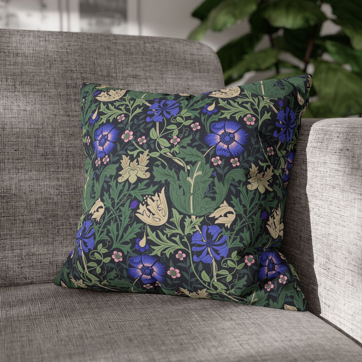 Floral patterned pillow on a gray sofa with a blurred background